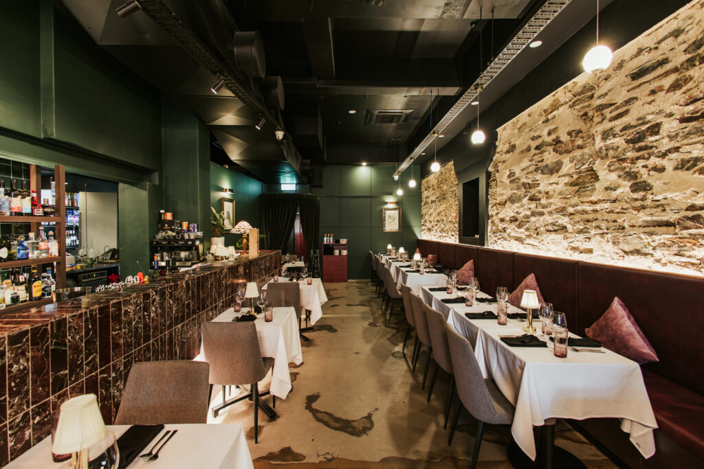 Deep green and Burgundy colour palette, moody lighting and bespoke wine display cabinetry for this hospitality fit out for Thai Room